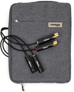 Vista dall’alto di un cavo phono Thorens PhonoConnect PHS 150 XLR-XLR 1,5 m nero con guaina intrecciata, quattro connettori metallici neri con estremità dorate e anelli rosso e argento, appoggiato su una custodia in tessuto grigio antracite con targhetta Thorens