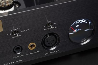 Close-up front view of the black Cayin HA-3A, brushed aluminum casing with 6.35 mm and 4.4 mm headphone jacks, 4-pin XLR connector, two metal switches, and a round backlit VU meter with a red needle
