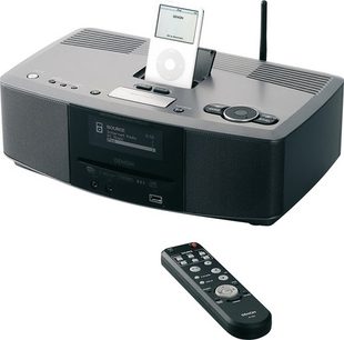 Denon S-52 sort mini-stereoanlæg set forfra og med fjernbetjeningen, placeret på en grå overflade med en hvid iPod