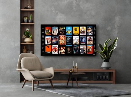 Televizor care afișează o selecție de filme și seriale, fotoliu bej și etajeră din lemn cu plante într-un living cu perete gri