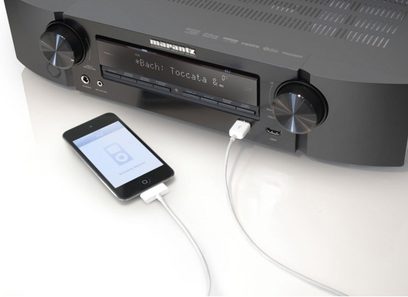 Marantz NR1604 sort hjemmebiografsforstærker, set forfra med display, knapper og stik, iPhone tilsluttet på forsiden med kabel