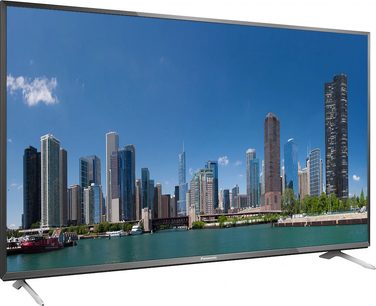 Panasonic TX-65CX700 television displaying a panoramic view of a modern waterfront city