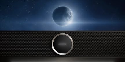 Zwarte soundbar van voren gezien met centraal verlichte ronde knop tegen een achtergrond van nachtelijke hemel en maan
