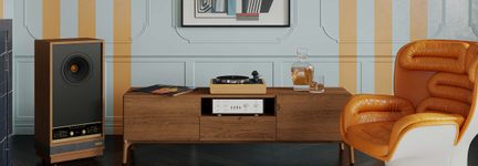 Mobile basso in legno con giradischi, amplificatore e caraffa, diffusore in legno con frontale nero e poltrona in pelle arancione, vista frontale