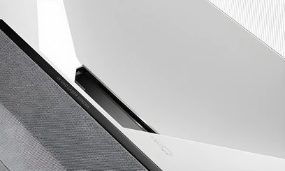 Optoma CinemaX P2 ultrakort brændvidde videoprojektor, set fra siden, hvid og sort kabinet med sort gitter øverst