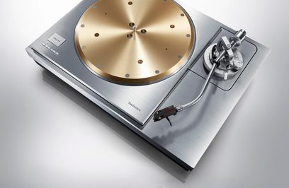 Hi-fi vinylspelare Technics SL-1000R med guldfärgad tallrik, silverfärgad böjd tonarm och rektangulär bas i borstat metall.