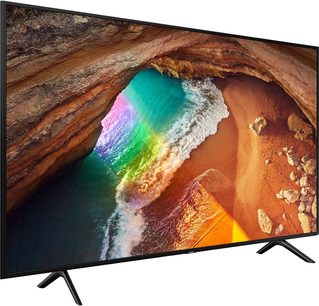 Samsung QE43Q60R TV set forfra, skærmen viser en grotte med en regnbue, smal sort ramme