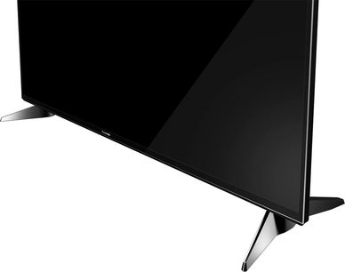 Panasonic TX-49EX600E fladskærms-tv i sort, set fra tre kvart bagfra, på sølvfarvet metalfod