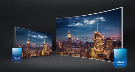 Dos pantallas curvas que muestran una ciudad iluminada por la noche con altos rascacielos, una en Full HD y la otra en Ultra HD 4K