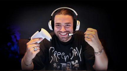 Person facing forward wearing a black-and-white plastic headset with microphone, holding a white plastic game controller