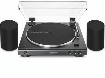 Svart Audio-Technica-vinylspiller med gjennomsiktig lokk, omgitt av to svarte Sonos-høyttalere