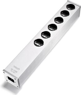 Multiprise Inakustik AC-3200 Filter Analog SCHUKO i børstet sølvfarvet aluminium, set i let fugleperspektiv, med seks runde sorte stikkontakter på række på oversiden og en IEC-strømforsyningsforbindelse i den ene ende.