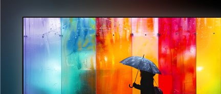 Televizor s velmi tenkým černým kovovým rámem, skleněná obrazovka zobrazující vícebarevné přechody, pohled zepředu