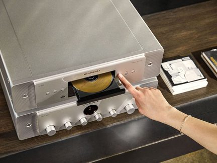Ασημένιο μεταλλικό CD player Marantz με βουρτσισμένη επιφάνεια, ανοιχτό δίσκο με χρυσό δίσκο, κουμπιά και θύρα USB στο μπροστινό μέρος, άποψη από ψηλά