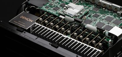 Denon AVC-X6500H sort hjemmebiografsforstærker, set oppefra med printplade med elektroniske komponenter og kølevinger