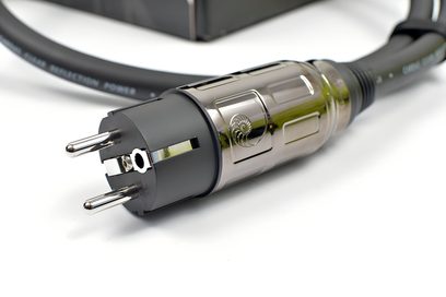 Кабел за захранване Cardas Clear Reflection Power в черен цвят с дебела гумена обвивка, двуцветен европейски мъжки штекер в черно и полирано златно, украсен с релефен лого, засенчен страничен изглед