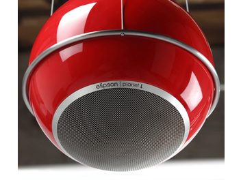 Enceinte sphérique rouge et blanche suspendue, grille noire circulaire au centre, vue rapprochée de face légèrement en contre-plongée