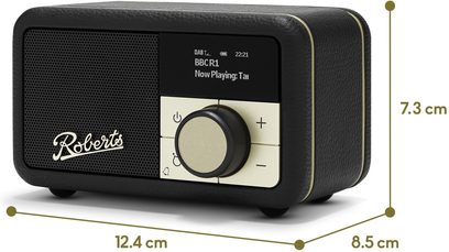 Roberts Revival Petite 2 bordradio i sort med kornet kunstlæder, set fra trekvart forfra, med sort metalhøjtalergitter til venstre, lille digitalt display øverst til højre og gyldent betjeningspanel med stor central drejeknap og plus/minus-knapper