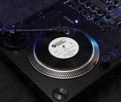 Černá vinylová deska z kovu/plastu, šikmý pohled, otočný talíř s měřítkem, vinyl 7" s adaptérem na 45 otáček, raménko pro čtení