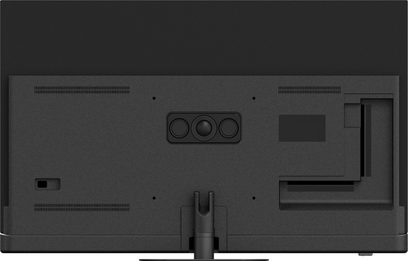Panasonic TV-55Z90B high-definition television, matte black with textured plastic finish and metal stand, rear view, central rectangular camera module with circular lens flanked by two sensors, slim ventilation grilles at the top and bottom, side connectivity compartment