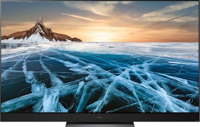 Panasonic TX-55HZ2000E-fladskærm, der viser et billede af sneklædte, bjergtinder, der rager op fra en frossen sø ved solnedgang