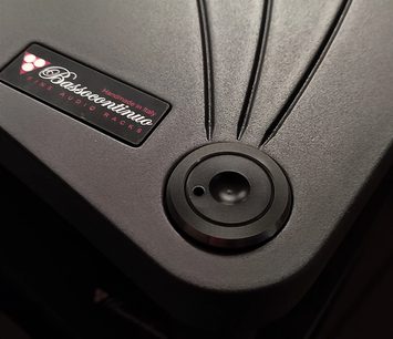 Cirkulær sort højttaler set forfra med "Bassocontinuo"-logo og teksten "Handmade in Italy Fine Audio Racks" på metalskilt