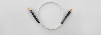 Audio cable with two gold-plated connectors at the ends, forming a loop on a solid gray background