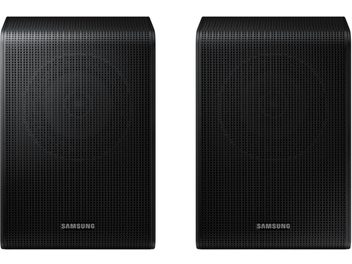 Galinė „Samsung SWA-9250S“ garsiakalbių pora, juodas stačiakampis plastikinis korpusas, priekinė dalis su perforuoto metalo grotelėmis ir centre apačioje esančiu „Samsung“ logotipu, šiek tiek suapvalinti kraštai, vaizdas iš priekio