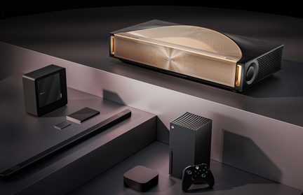 Instalace domácího kina z pohledu shora, černý a zlatý projektor UST s kovovým čelem, soundbar, konzole a ovladač