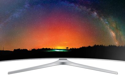 Buet Samsung UE55JS9000-tv, der viser en nattehimmel med stjerner og en orange nordlysglød over en mørk skov