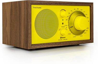 Radio da tavolo Tivoli Model One BT anni '70 gialla, custodia in legno, altoparlante rotondo e grande pulsante, vista 3/4 anteriore sinistra