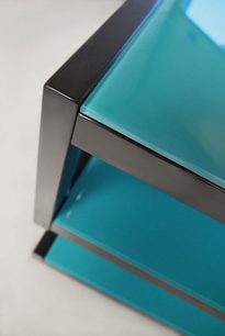 Norstone Design Esse lagune-blåt audio-/videomøbel, detalje af et hjørne med sorte kanter og sider i blåtonet glas