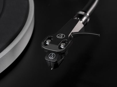 Sort Audio Technica AT-LP5X pladespiller, nærbillede i dykning af tonearmen med pickup og modvægt