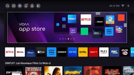 Startskærm på en smart-tv-grænseflade med ikoner for populære apps og en reklamebanner