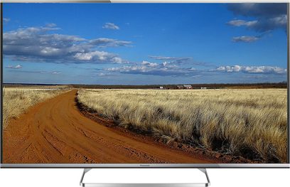 Panasonic TX-60AS650E-fladskærm, der viser et landligt landskab med gyldent hvedemark, grusvej og blå, skyet himmel