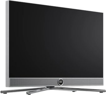 Loewe Vega 32 -televisio, musta ja hopea, litteä näyttö etupuolen kaiutinritilällä ja ristikkäisellä metallijalalla