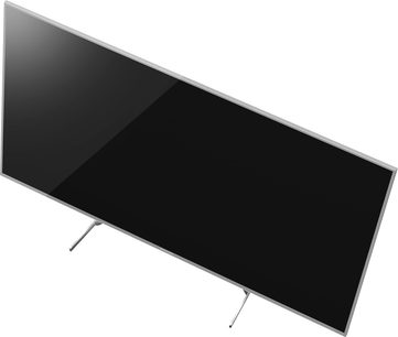 Fladskærms-TV fra Panasonic TX-50EX700E med rektangulært sort panel, set forfra, stående på to sølvfarvede metalben