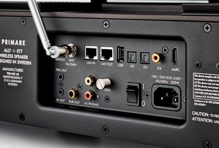 Närbild av en svart bakpanel i metall på en högtalare: RJ45, USB, optisk, HDMI eARC, RCA, IEC-kontakt