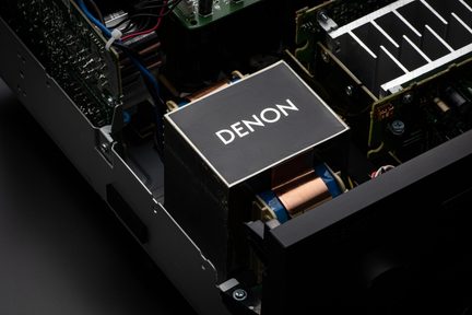 Denon-Audiotransformator im Inneren eines schwarzen Hi-Fi-Verstärkers, sichtbare elektronische Bauteile