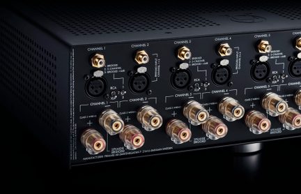Bagpanel på lydforstærker med 6 kanaler, hver med 3 XLR-stikforbundne stik og en vælger til klasse 2 eller 3 kabling