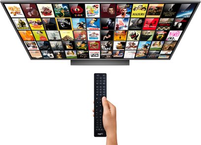 Černé dálkové ovládání Zappiti s 52 podsvícenými tlačítky před televizní obrazovkou zobrazující mřížku náhledů filmů a seriálů