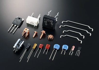 Įvairūs elektroniniai komponentai ir garso jungtys išdėstyti ant tamsiai pilkos spalvos fono, žiūrint iš viršaus nuo aukštai