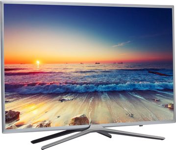 Samsung UE40K5600 TV-skærm, der viser en solnedgang på en strand med bølger og klipper i forgrunden