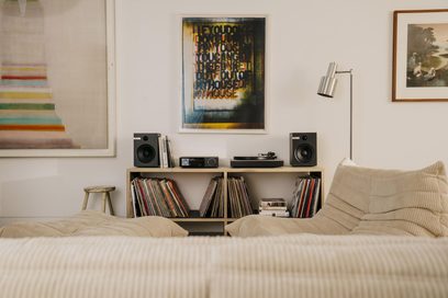 Amplificatore hi-fi integrato stereo Cambridge Audio EVO 150SE, chassis rettangolare in metallo nero con pannelli laterali in legno, frontale in vetro nero con un grande pulsante argentato e display centrale, vista frontale