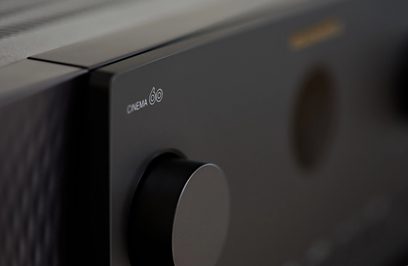 Marantz Cinema 60 fekete otthoni mozierősítő, közelről a bal felső sarok, fehér logó matt fekete panelen