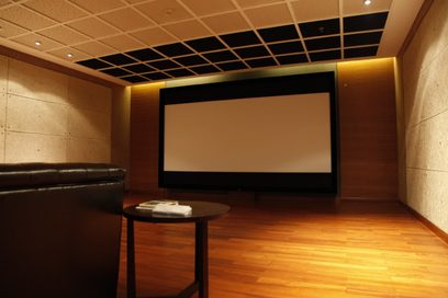 Screen Excellence TAM 2 Enlightor 4K 160 projektionsskærm i et privat hjemmebio-rum med sort akustisk loft