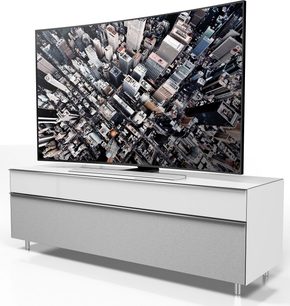 Biała szafka TV Spectral Scala SC1657 z płaskim ekranem wyświetlającym gęstą panoramę drapaczy chmur w dużym mieście