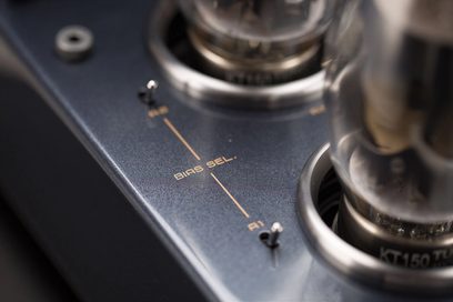Cayin CS-150A sølv stereorørforsterker, nærbilde i trekvart vinkel ovenfra av det satinerte metallchassiset som viser to KT150-rør, en vippebryter og den vertikale påskriften «BIAS SEL.»