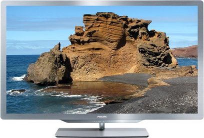 Philips 47PFL7606H-fladskærms-TV, der viser et billede af eroderede klipper ved vandkanten, set forfra, med sølvfarvet fod