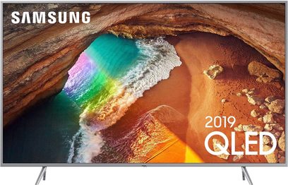 Samsung QE65Q64R 65" QLED-TV viser et luftfoto af en strand med regnbuebølger og gyldne klipper